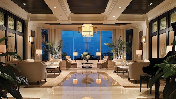 A spacious lobby with a central coffee table, comfortable seating, and large windows offering a view.