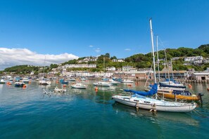 A harbor with multiple boats docked, a clear blue sky, and buildings in the background. - 3 Bed in Looe (oc-l10098) (Looe)