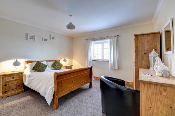 A bedroom with a wooden bed, bedside lamps, a desk with a chair, a window with curtains, and a wardrobe. - 2 Bed in Y Felinheli (oc-wag431) (Y Felinheli)