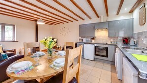 A modern kitchen with grey cabinets, a microwave, a red kettle, and a sink. - 2 Bed in Y Felinheli (oc-wag431) (Y Felinheli)