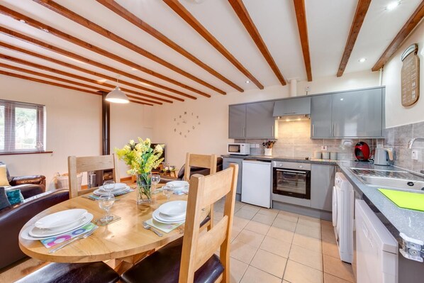 A modern kitchen with grey cabinets, a microwave, a red kettle, and a sink. - 2 Bed in Y Felinheli (oc-wag431) (Y Felinheli)