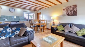 A living room with two sofas, a coffee table, and a dining area with a table and chairs. - 2 Bed in Y Felinheli (oc-wag431) (Y Felinheli)