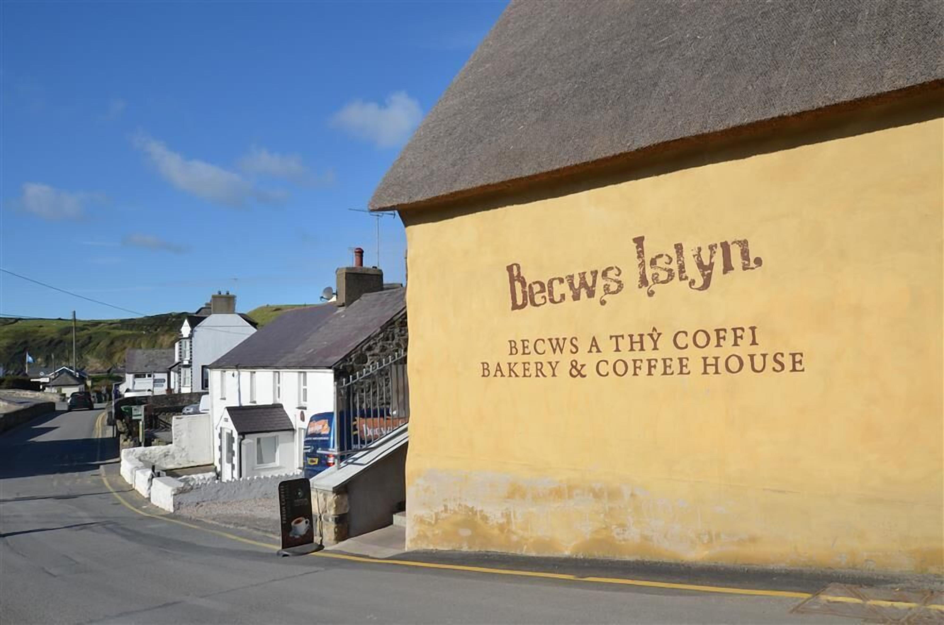 Un bâtiment sur lequel on peut lire l’inscription suivante : « BECWS A THY COFFI BAKERY & COFFEE HOUSE ».