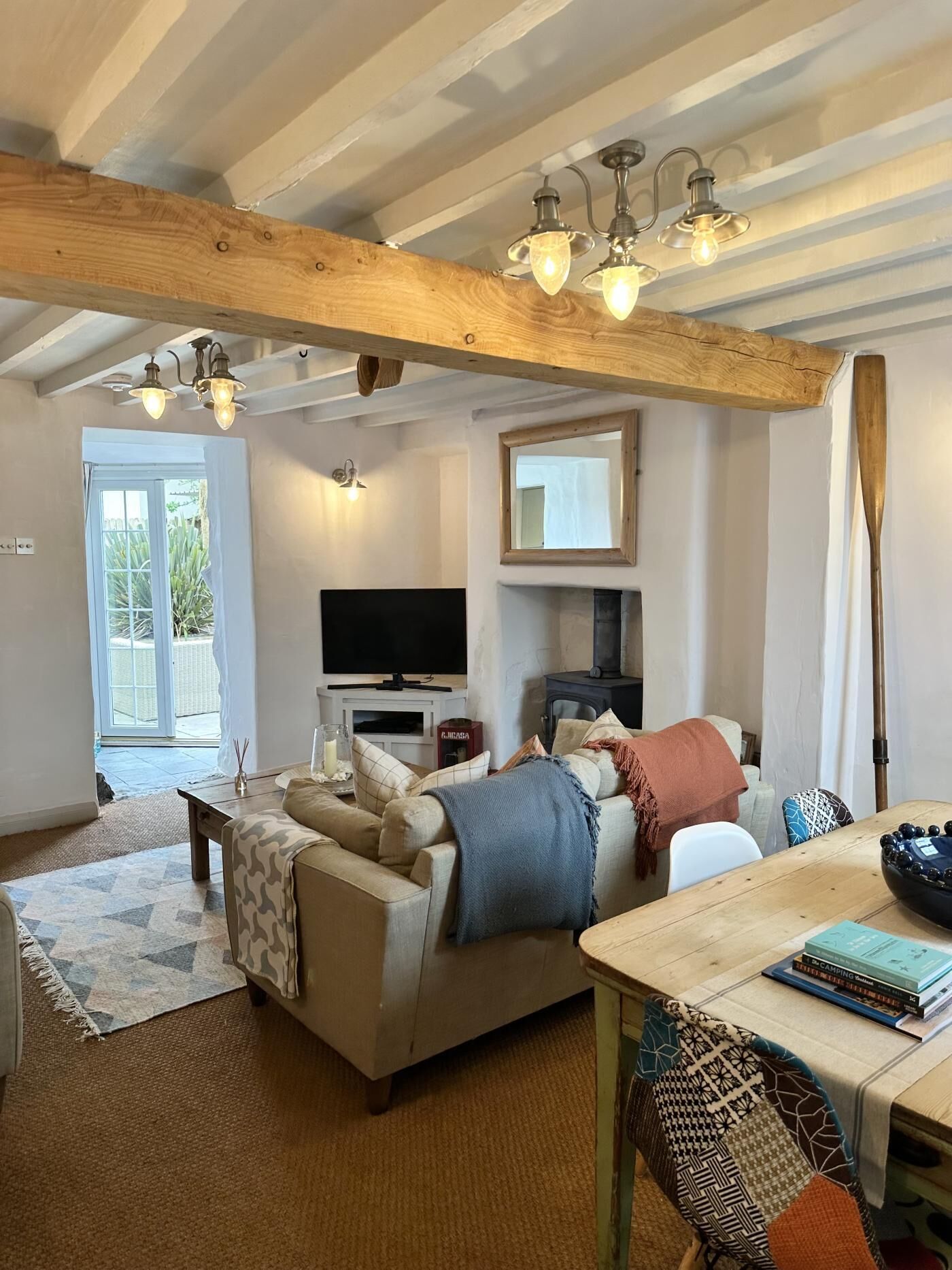 Un salon chaleureux avec un canapé, une table basse et une cheminée. Il y a une télévision et un miroir au mur.