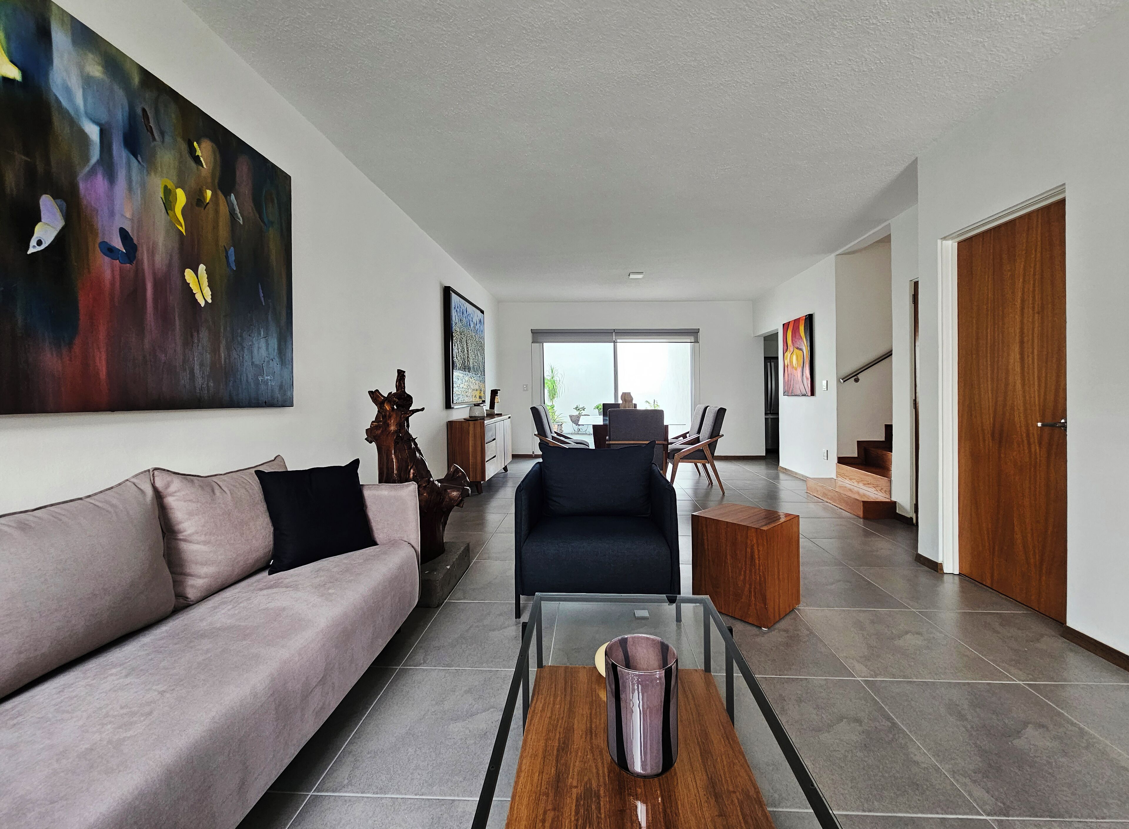 Un salon moderne avec un canapé, une table basse et des œuvres d’art accrochées aux murs.