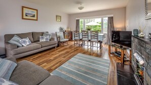 Una sala de estar con sofá, televisión, chimenea y comedor.