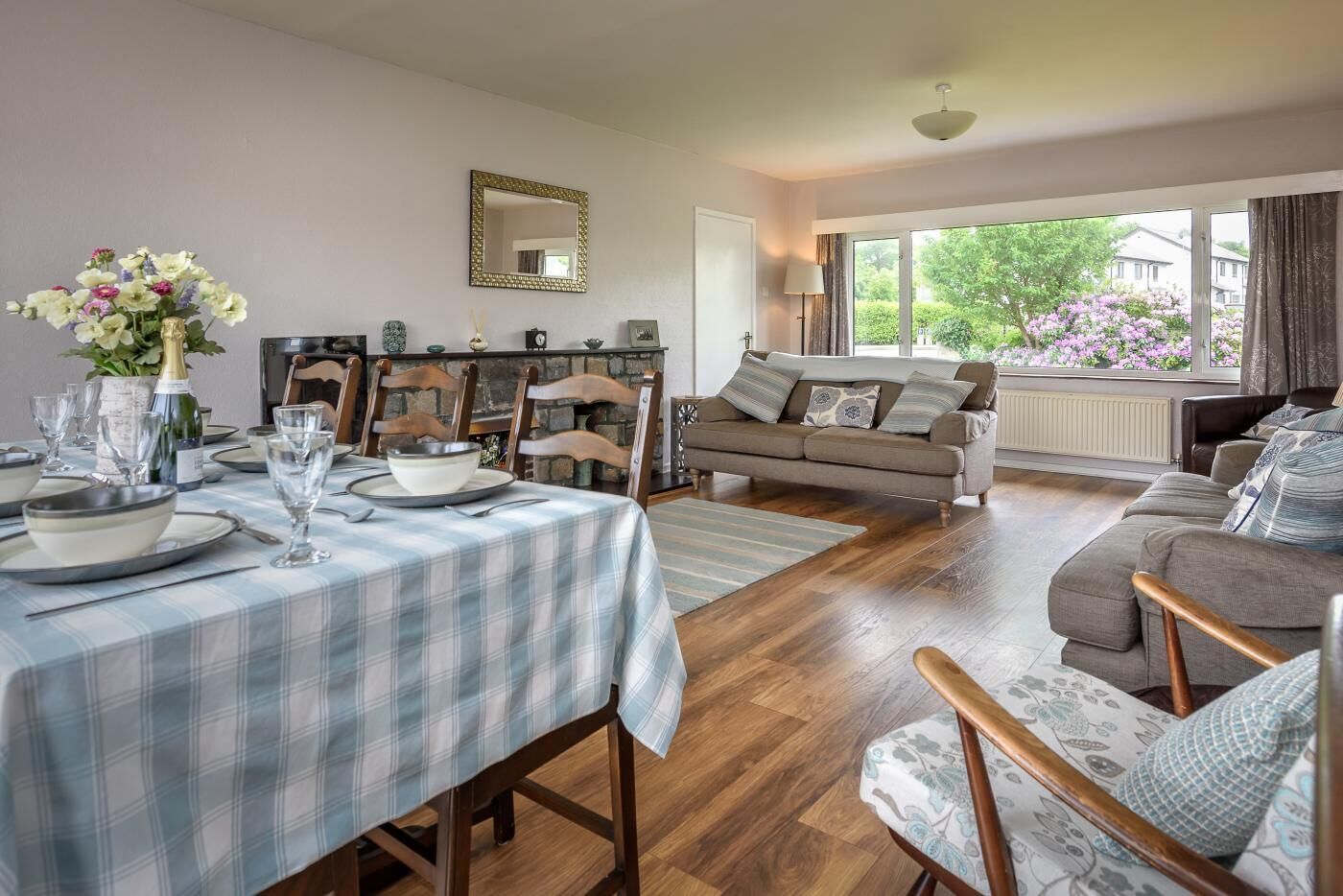 Un comedor con una mesa preparada para cuatro personas, un sofá y una chimenea.