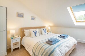 A bedroom with a bed, two bedside tables, a window, and a view of the outdoors. - 4 Bed in Pwllheli (oc-watern) (Abersoch)