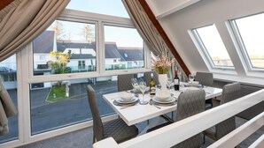 Comedor con mesa para cuatro, ventanas amplias y vista al exterior.