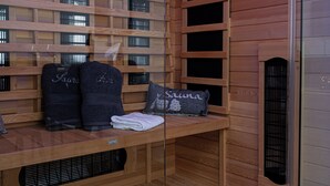 Una sauna con bancos de madera, toallas y una almohada con la palabra 'Sauna'.