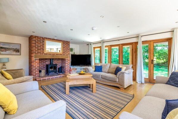 A living room with a fireplace, a television, a sofa, and a coffee table. - 4 Bed in Fakenham (oc-1261) (Thursford)