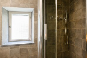 Een douche, een bidet, handdoeken, toiletpapier