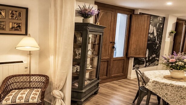Ein Essbereich mit Tisch, Stühlen, einem Schrank und einer Lampe.