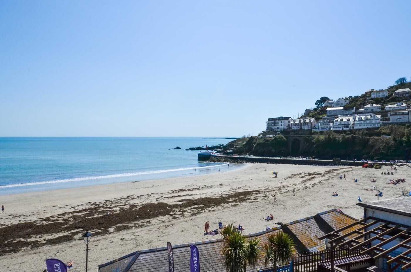 Une plage offrant une vue dégagée sur la mer, un rivage sablonneux et des bâtiments situés sur une colline.