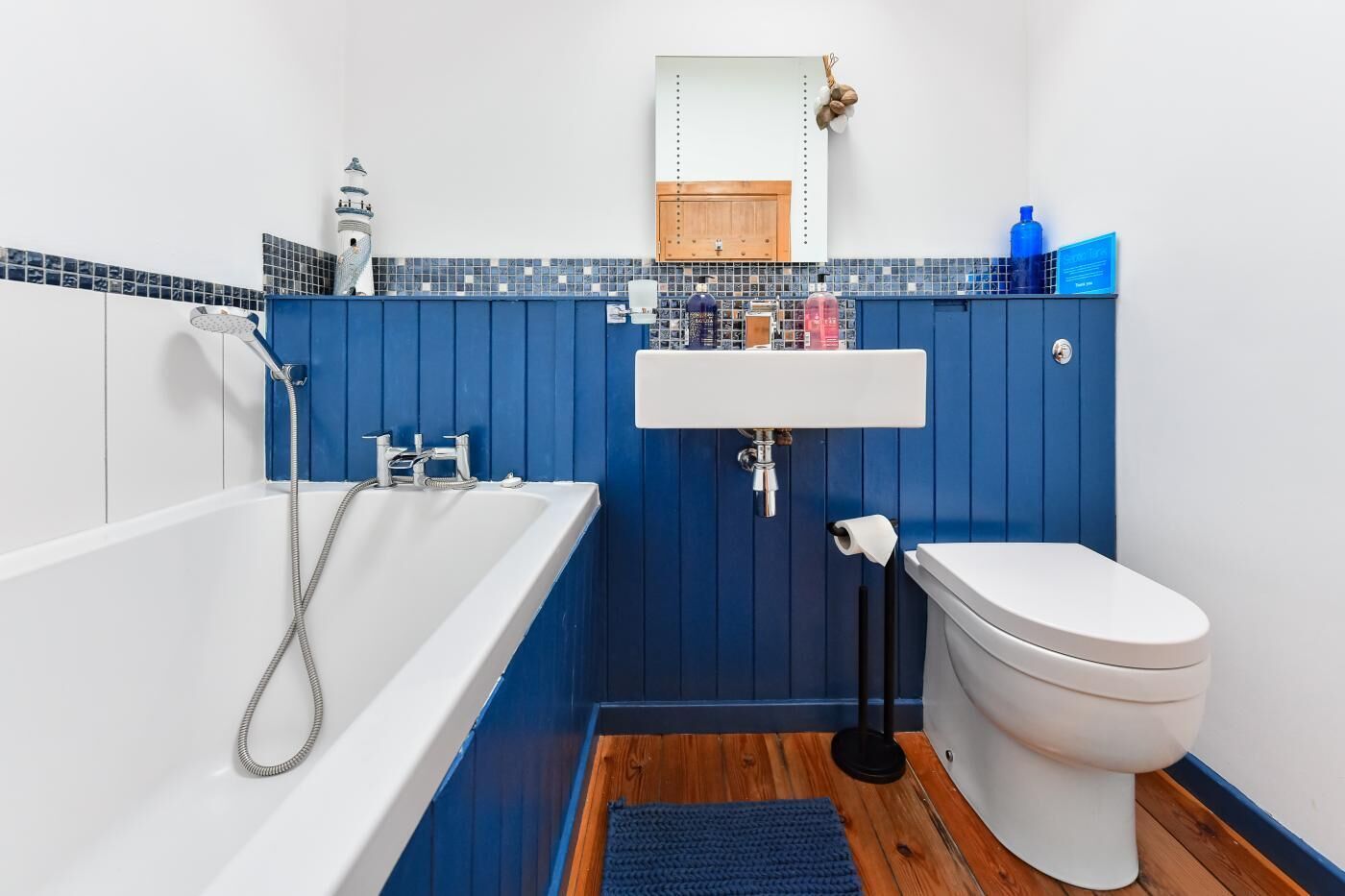 Une salle de bain avec une baignoire blanche, des toilettes blanches et un lavabo.