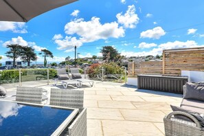 A patio area with outdoor seating, a pool, and a view of the sea. - 2 Bed in Abersoch (oc-taflia) (Abersoch)