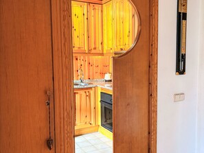 Ein Holzinterieur mit Küchenbereich, inklusive Schränken, einer Spüle und einem Herd.