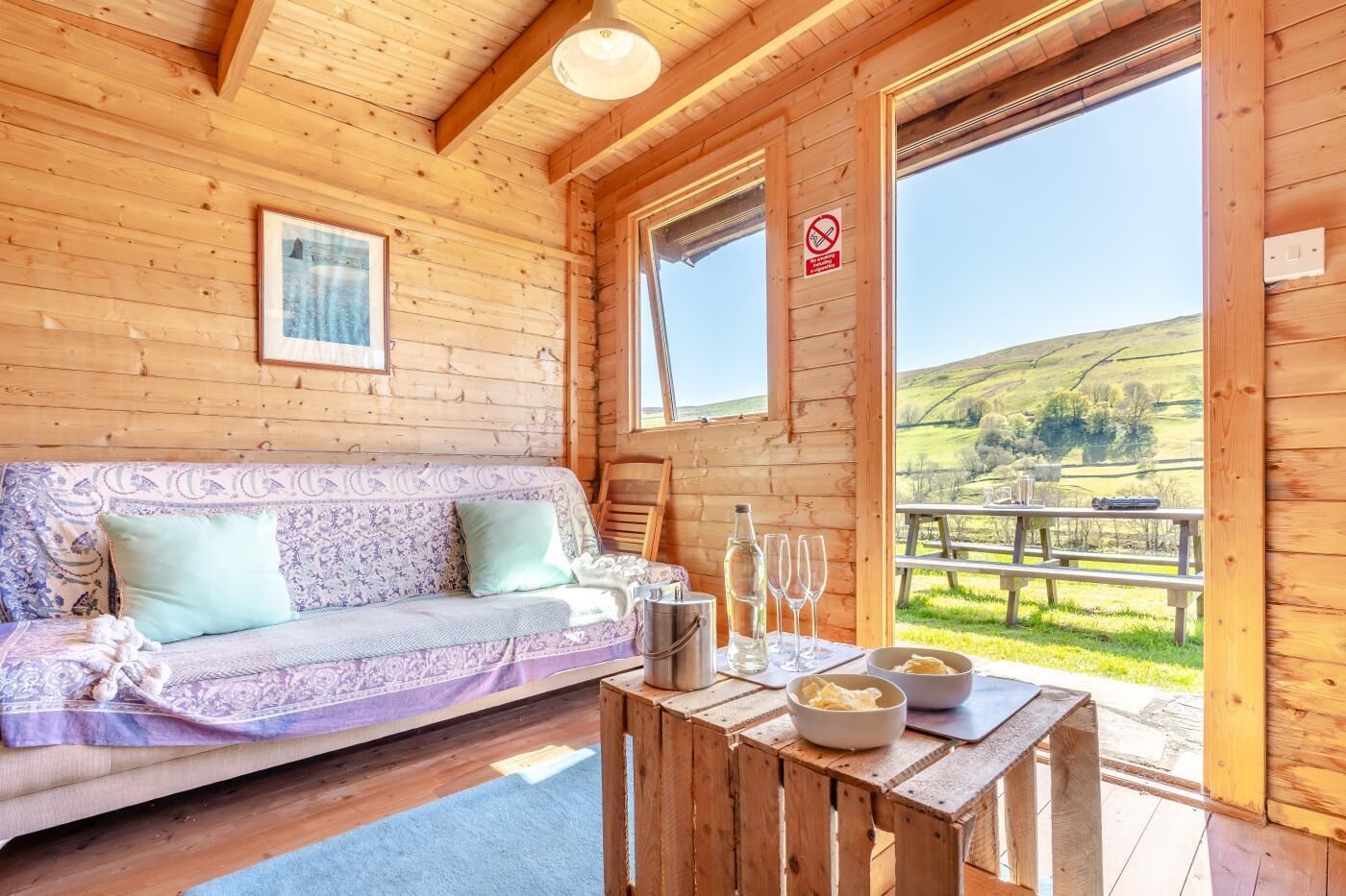 Een houten cabinemeubilair met een bank, tafel en een mooi uitzicht op het landschap.