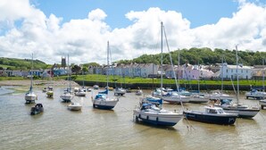 Un port où de nombreux bateaux sont amarrés, une église en arrière-plan et des maisons le long de la côte.