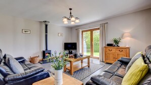 Ein Wohnzimmer mit Kamin, Fernseher und Essbereich.