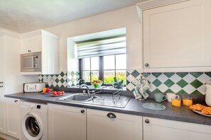 Una cucina moderna con lavatrice integrata, forno a microonde e una finestra con vista.