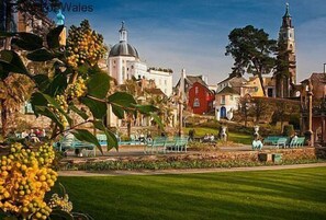 A park with benches and a church with a dome and tower. - 2 Bed in Porthmadog (oc-82928) (Bryncir)