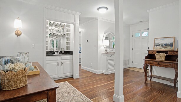 A spacious kitchen with white cabinetry, a wooden dining table, and a wicker basket. - Evian 157- 2BR/2BA Pool & Tennis Courts (Hilton Head Island)