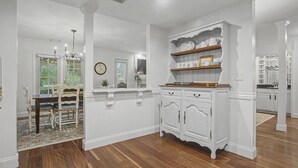 A spacious room with a wooden floor, white walls, and a built-in white cabinet with shelves. - Evian 157- 2BR/2BA Pool & Tennis Courts (Hilton Head Island)