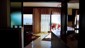 A spacious living area with a view of the sea, a dining area with red chairs, and a kitchen visible through an open door. - Discover your exclusive oasis in Ganzirri: the villa overlooking the Strait (Messina)
