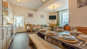Una cocina moderna con armarios de madera, una mesa de comedor preparada para seis personas y un banco.