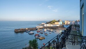 A coastal town with a historic building, a harbor with boats, and a view of the sea. - 2 Bed in Tenby (oc-25953) (Tenby)