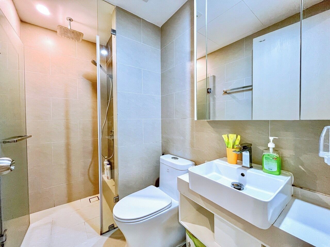 A modern bathroom with a shower, toilet, and sink.