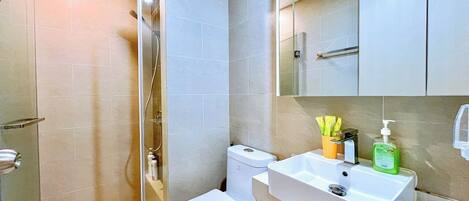 A modern bathroom with a shower, toilet, and sink.