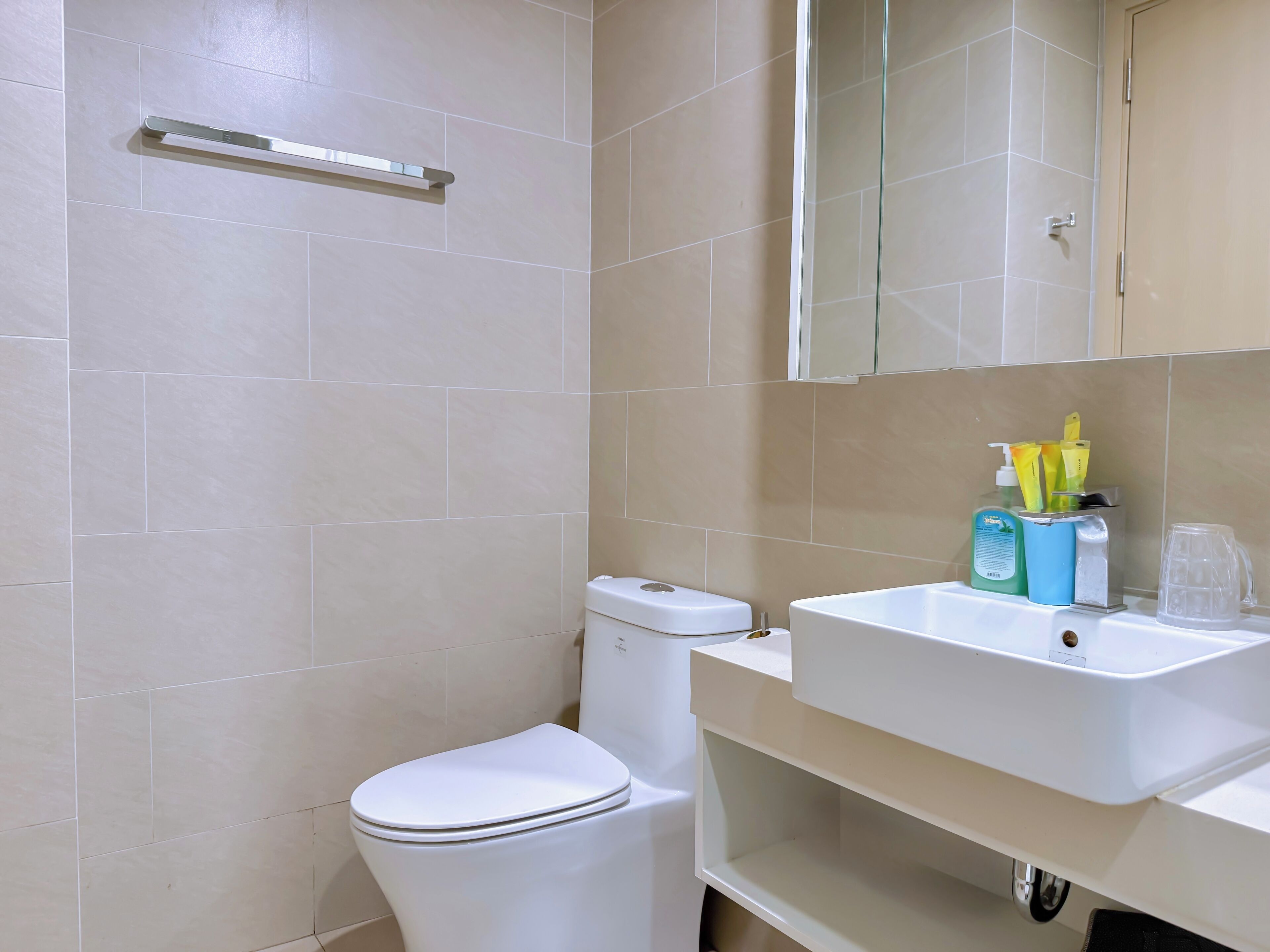 A bathroom with a toilet, a sink, and a mirror.