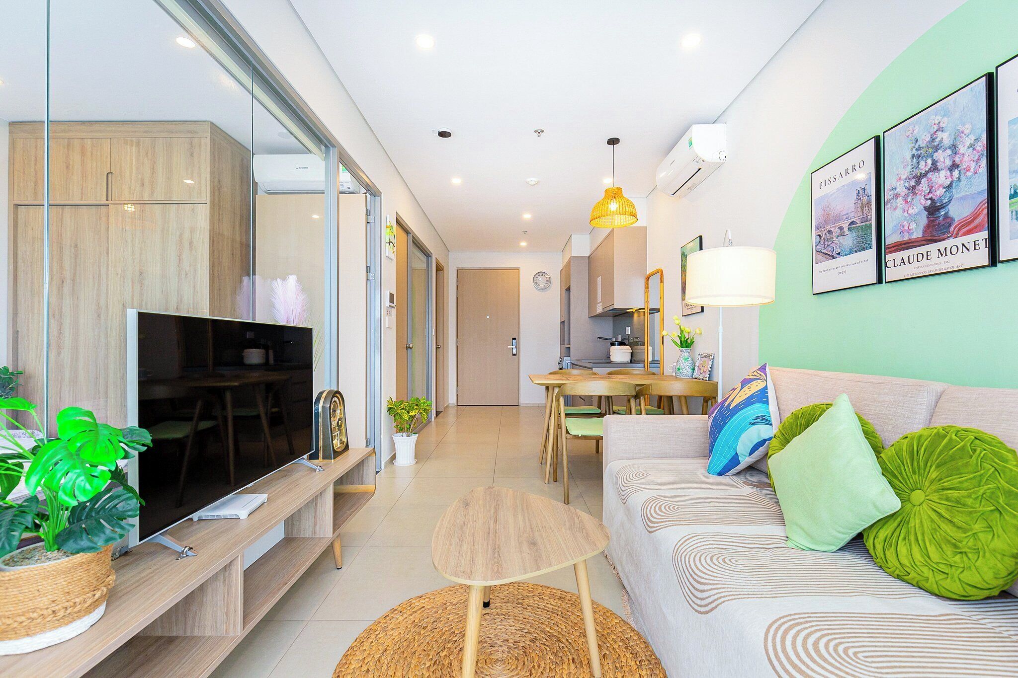 A modern living room with a TV, sofa, and dining area.