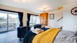 Ein Schlafzimmer mit einem Bett, einem Holzschrank, einem Schreibtisch und einem großen Fenster.