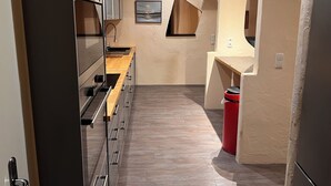 Een moderne keuken met roestvrijstalen apparatuur, houten werkbladen en een visgraatvloer.