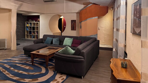 Een moderne woonkamer met een modulaire bank, een bijzettafeltje en een kamerbreed tapijt met een patroon.
