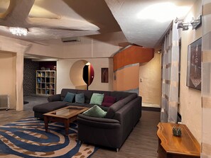 Een moderne woonkamer met een modulaire bank, een bijzettafeltje en een kamerbreed tapijt met een patroon.