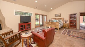 Una sala de estar con chimenea, televisor, sofá, mesa de centro y estantería.