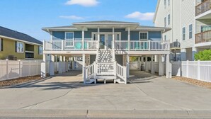 A two-story building with a balcony and a staircase leading to the upper level. - Shore Beats The Heat- 4BR in Cherry Grove- Pool (North Myrtle Beach)