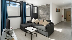 En moderne stue med en grå hjørnesofa, et hvidt sofabord og en grå accentvæg.