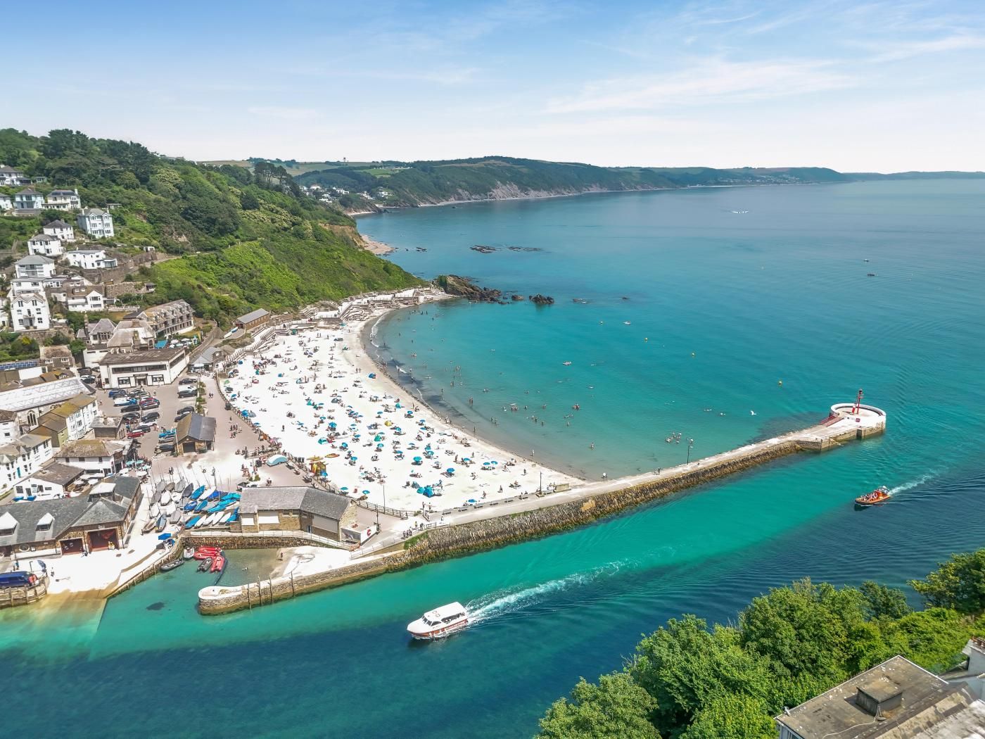 A coastal town with a beach, a pier, and a boat dock.