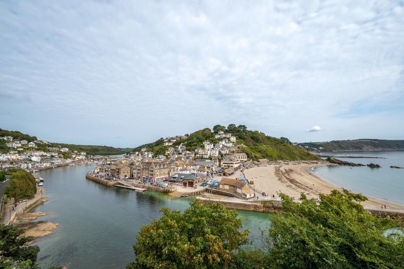 A coastal town with a harbor, buildings, and a beach.