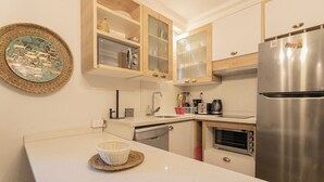 Een moderne keuken met een roestvrijstalen koelkast, een inbouwoven en houten keukenkastjes.