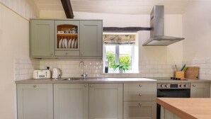 A kitchen with light-colored cabinets, a window with a view, a stove, and a sink. - 2 Bed in Carmel (oc-wai211) (Carmel)