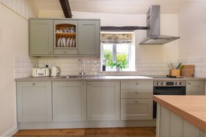 A kitchen with light-colored cabinets, a window with a view, a stove, and a sink. - 2 Bed in Carmel (oc-wai211) (Carmel)