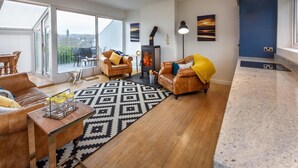 Un salón espacioso con un gran ventanal, una chimenea y una zona de estar acogedora.