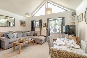 A modern living room with a sofa set, a dining table set for four, and a TV on a stand. - 2 Bed in Fowey (oc-p00650) (Fowey)