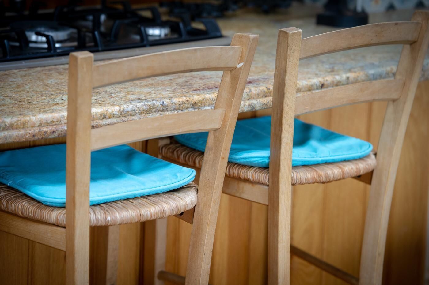 A wooden chair with a woven seat and backrest, and a blue cushion.